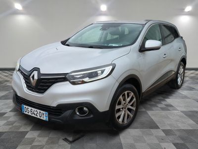 une voiture blanche est garée sur le sol à carreaux d'un garage