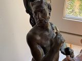 a statue of a man holding a bird next to a vase
