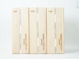 trois livres sont empilés sur une surface blanche