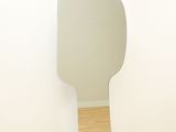 a mirror on the wall of a room with a wooden floor