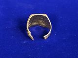 a close up of a gold ring on a blue surface