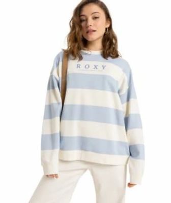 une femme portant un pull rayé bleu et blanc et un pantalon blanc