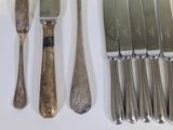 a lot of silverware on a table with a knife and fork