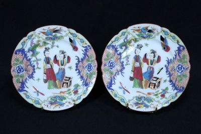 pair of chinese porcelain plates with figures on them on a black background