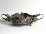 an antique silver plate with a decorative design on it