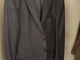 gray and black plaid jacket hanging on a hanger in a closet