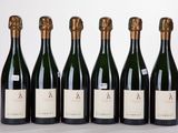six bouteilles de vin sont alignées sur une surface blanche