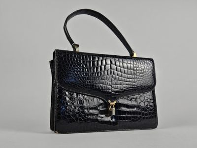 un sac à main en cuir de crocodile noir sur fond blanc