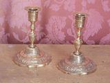 deux bougeoirs en argent posés sur une table en bois