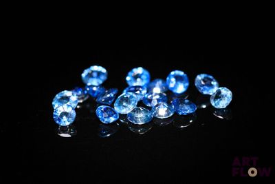 de très jolis diamants bleus posés sur une surface noire