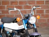 a blue and white motorcycle parked in front of a brick wall