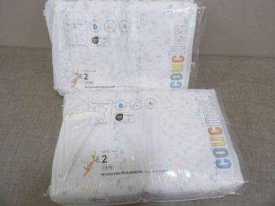 trois sacs contenant des couvertures blanches pour bébé, posés sur un canapé