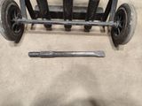 a metal object that is sitting on the ground next to a hammer