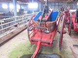 a horse pulling a cart in a barn with other horses