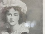 portrait of a woman in a hat and dress with a flower in her hair
