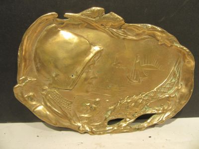 a gold plate with a fish on it sitting on a table