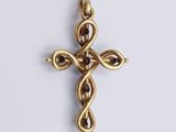 a close up of a gold cross with a knot in the middle