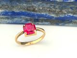 gros plan d'une bague en or avec une pierre en rubis