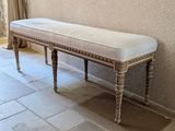 a bench with a white cushion on it in a room