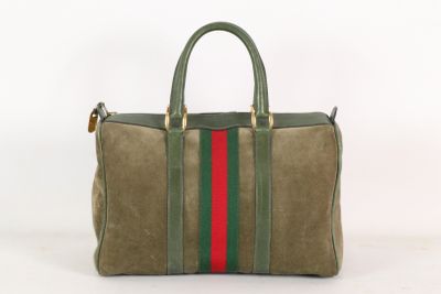 le sac rayé vert et rouge est posé sur une surface blanche