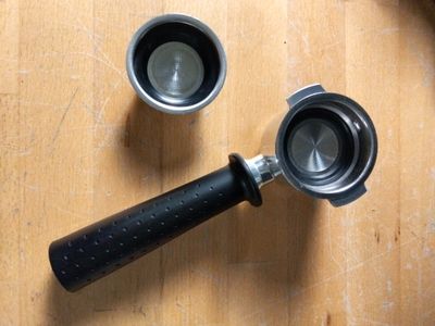 une poignée noire sur un moulin à café posé sur une table en bois