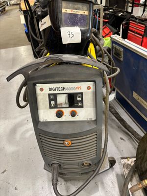 une photo d'une machine à souder dans un entrepôt, avec d'autres équipements en arrière-plan