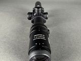 a close up of a rifle scope on a gray surface