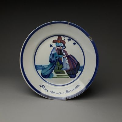 une assiette bleue et blanche sur laquelle figure l'image d'un homme tenant un sac