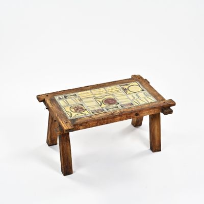 une petite table en bois recouverte d'un plateau en carrelage