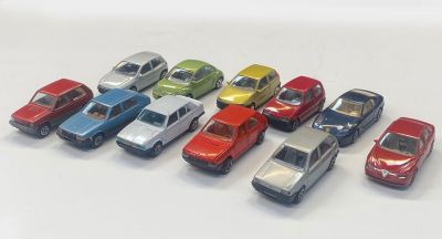 several toy cars are lined up in a row on a white surface
