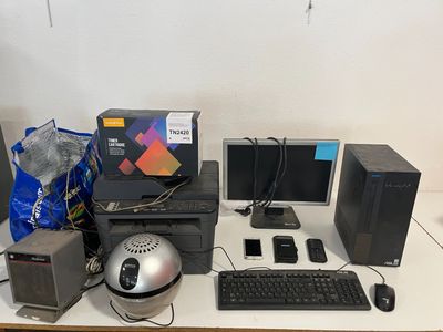 un bureau sur lequel se trouvent un ordinateur, un clavier, une souris et d'autres objets