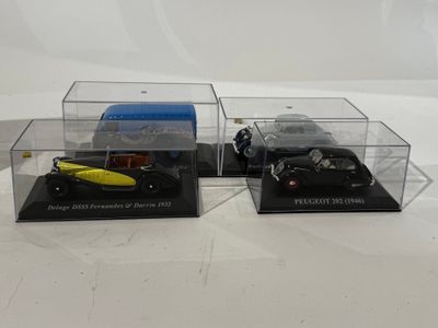 deux modèles réduits de voitures dans une vitrine posée sur un support blanc