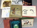 Plusieurs livres sont empilés les uns sur les autres par terre.
