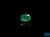 a green emerald stone on a black surface