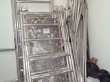 un tas d'échelles et un seau de déchets dans un garage
