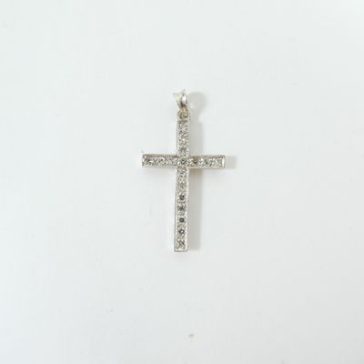 un gros plan d'une croix sur une surface blanche, ornée de diamants