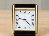 a black and gold clock sitting on a wooden table