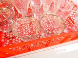 des bouteilles et des verres posés sur un plateau posé sur un comptoir, avec un plateau rouge