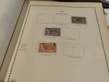 an open book with stamps on it sitting on a table