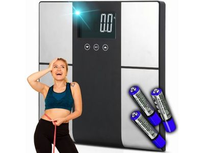 the woman is standing next to a scale with batteries on it