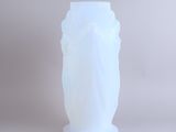 a white vase sitting on a table with a white background