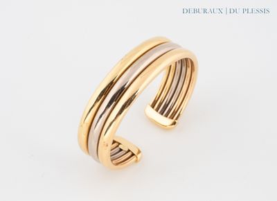 un gros plan d'un bracelet manchette en or et argent sur fond blanc