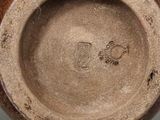a close up of a vase with a brown base