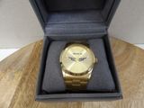 a gold watch in a box on a wooden table