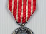 an image of a medal with a red and white stripe ribbon