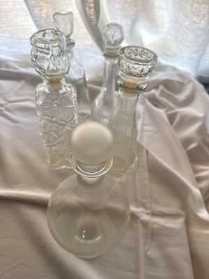 three glass vases sitting on a table with a white cloth