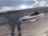 a close up of a car door handle with a reflection of a person
