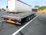 un camion à plateau garé sur un parking