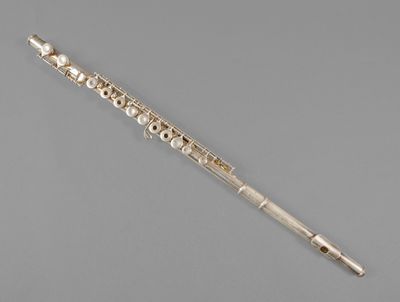 a silver flute with a wooden handle on a gray surface