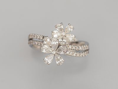 Bague ajourée en or gris 750°/°° (18K), ornée de deux fleurs…